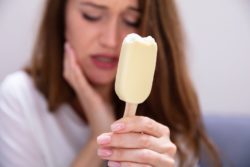 woman with cavity holding jaw in pain after eating ice cream dental fillings dentists Jacksonville Florida